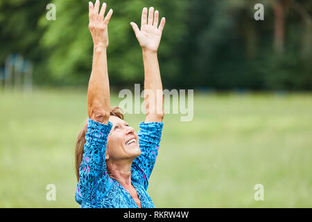 Senior woman doing yoga relaxation pour un exercice dans la classe de bien-être dans la nature Banque D'Images