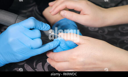 Manucure est l'application electric lime à ongles manucure à percer sur les doigts. Banque D'Images