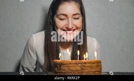 Happy Girl émotionnel souffle les bougies pendant la célébration de son anniversaire et applaudit, Close up. Banque D'Images