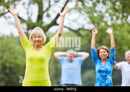 Groupe de personnes âgées dans une salle de sport au cours de la formation retour en rehab Banque D'Images