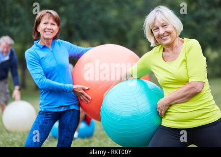 Deux femmes âgées avec boule d'exercice dans un rehab retour dans le parc du cours Banque D'Images