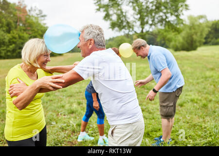 Groupe de personnes âgées au jeu de ballon sur une partie de l'été ou anniversaire Banque D'Images