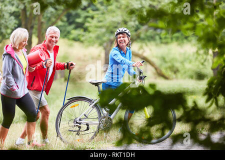 Exercice d'aînés dans la nature remise en forme avec des vélos de montagne et des bâtons de marche Banque D'Images