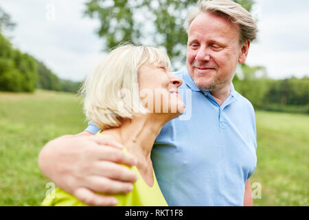 Amorous couple en marchant bras dessus bras dessous dans le parc en été Banque D'Images