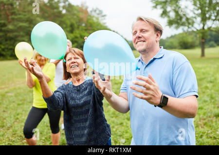 Heureux les aînés jouent avec des ballons sur une partie de l'été dans le jardin Banque D'Images