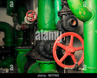 Les tuyaux d'approvisionnement en eau avec soupapes rouge dans local technique Banque D'Images