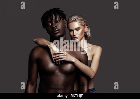 Jeune modèle hugging son beau petit ami afro-américain Banque D'Images