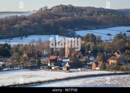 L'hiver une vue sur le village de Chiltern de Fingest avec neige au sol et Cobstone moulin sur la colline au-dessus. Banque D'Images