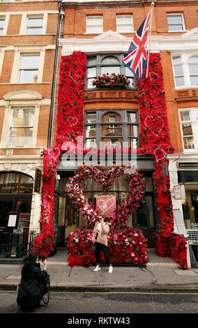 Les visiteurs de la Maddox Gallery de Londres se photographier devant la réalité augmentée Saint-valentin affichage floral. Banque D'Images