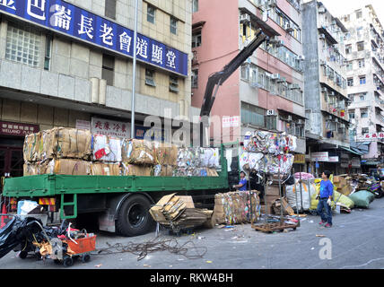 Blocs de déchets de papier en cours de chargement sur une grue sur camion rue de Sham Shui Po, Hong Kong. Banque D'Images