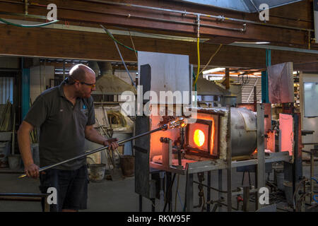 Souffleur de verre d'une traite chauffées dans un four. Banque D'Images