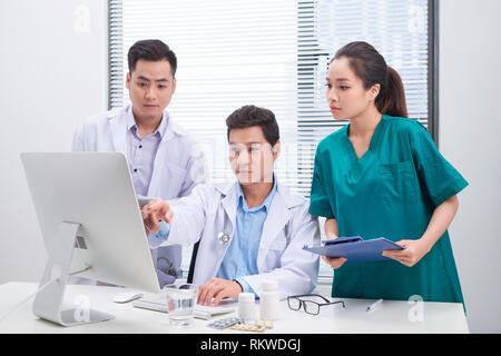 Trois médecins discuter sur des fichiers Office. Banque D'Images