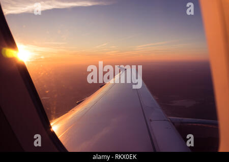 POV passager Vue à travers la fenêtre de l'avion, le lever du soleil au-dessus des nuages Aerial Banque D'Images