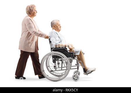 Profil de pleine longueur de balle une vieille femme poussant un homme âgé patient dans un fauteuil roulant isolé sur fond blanc Banque D'Images