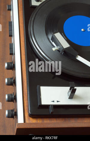 Old vintage vinyl record player dans la caisse en bois brun à l'enregistrement LP avec étiquette bleue. Vue de dessus gros plan photo verticale Banque D'Images