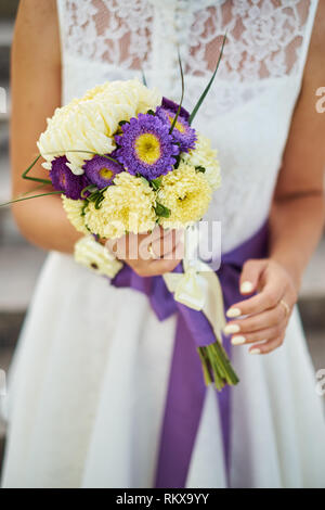 Belle jeune mariée en robe blanche holding bouquet de mariage, bouquet de mariée rose de spray, crème, rose pourpre rose, violet eusto Memory Lane Banque D'Images