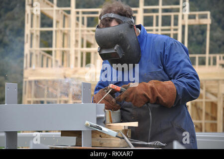Un soudeur prépare des poutres en acier pour un bâtiment sur un site de construction Banque D'Images