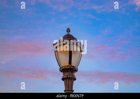 Lampe de rue contre le soleil dans le nuages rouges à Brooklyn Banque D'Images