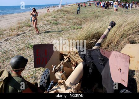 Seconde guerre mondiale soldat américain près de l'anti-char italien cannon déployés sur la plage de paestum au cours de reconstitution historique du débarquement de Salerne 1943 Banque D'Images