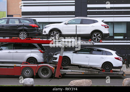 Expédition de voiture auto transport véhicule avec wagons chargés en face d'immeubles de bureaux Banque D'Images