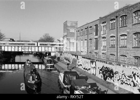 15-04 et les piétons le long de la rivière Lea La navigation à Hackney Wick, East London UK, avec le train au-dessus du pont raiiway en arrière-plan Banque D'Images