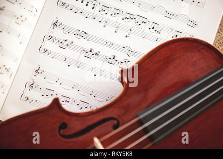 Amoureux de musique classique. Vue rapprochée de violon brun couché sur feuille de musique. Instruments de musique. Des appareils de musique. Cours de violon Banque D'Images