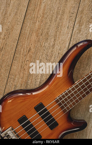 Apprenez à connaître votre instrument. Vue rapprochée de la guitare électrique corps avec cordes métalliques contre du plancher en bois. Music concept. Des appareils de musique. Instruments de musique. Banque D'Images