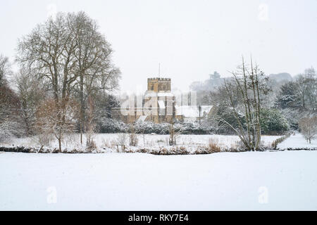 La grande église St James à Coln St Dennis dans la neige de l'hiver. Coln St Dennis , Cotswolds, Gloucestershire, Angleterre Banque D'Images