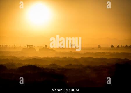 Plan large de l'agriculture d'une silhouette de tracteur au lever du soleil.