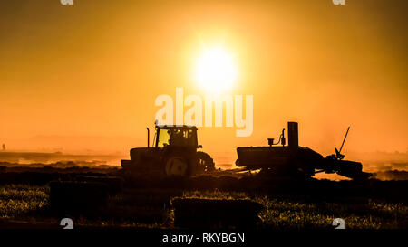 Plan large de l'agriculture d'une silhouette de tracteur au lever du soleil.