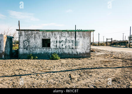 La sagesse graffiti peint sur le côté d'un bâtiment abandonné dans la ville en décomposition de Salton Sea Beach en Californie. Banque D'Images