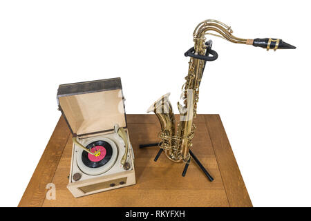 Vintage record player et saxophone sur table en bois isolé sur blanc. Banque D'Images