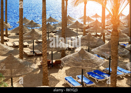 Des chaises longues sous un parasol sur la plage de la mer de sable en hotel Egypte, Sharm el Sheikh, notion de temps pour voyager Banque D'Images