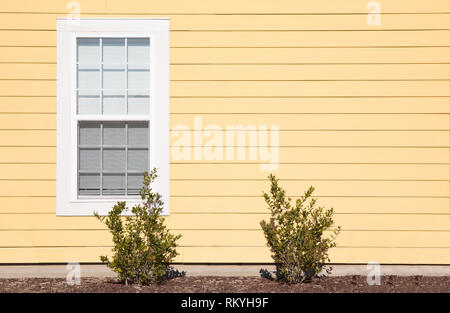 Un extérieur tourné d'une seule fenêtre avec parement jaune vif. Banque D'Images