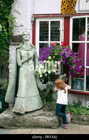 Enfant avec la statue de la femme sage de Wookey Hole à Glastonbury, Royaume-Uni (par artiste Phillipa Bowers) Banque D'Images