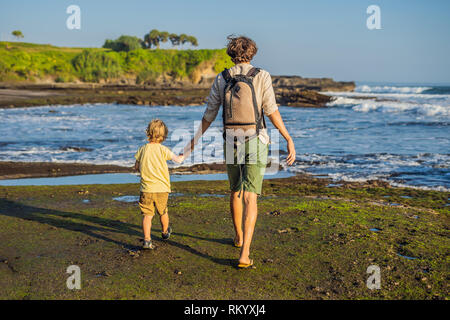 Père et fils les touristes sur l'arrière-plan de Tanah Lot - Temple dans l'océan. Bali, Indonésie. Voyager avec des enfants concept Banque D'Images