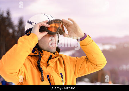 Une chaîne de montagnes reflétée dans le Portrait de l'homme masque de ski à la station de ski sur l'arrière-plan de la montagne et du ciel Banque D'Images