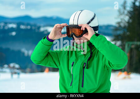 Une chaîne de montagnes reflétée dans le Portrait de l'homme masque de ski à la station de ski sur l'arrière-plan de la montagne et du ciel Banque D'Images