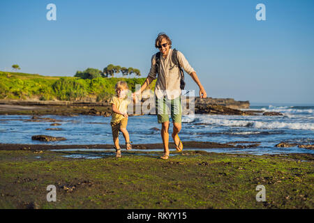 Père et fils les touristes sur l'arrière-plan de Tanah Lot - Temple dans l'océan. Bali, Indonésie. Voyager avec des enfants concept Banque D'Images