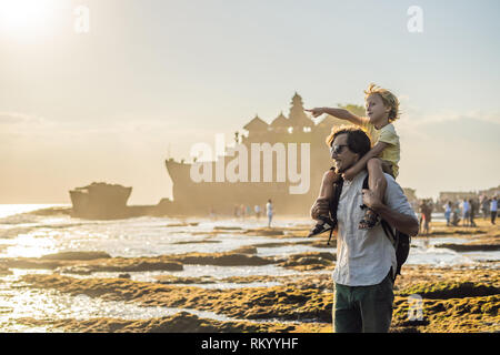 Père et fils les touristes sur l'arrière-plan de Tanah Lot - Temple dans l'océan. Bali, Indonésie. Voyager avec des enfants concept Banque D'Images