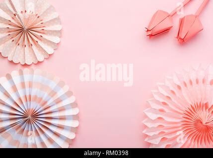 Le papier chinois fans de couleurs pastel rose sur table, vue de dessus, l'espace de copie de texte, de la mise au point sélective. Fleurs en papier en corail vivant. Banque D'Images