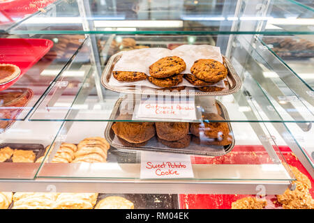 De nombreux cookies différents avec des signes sur des plateaux afficher dans le marché alimentaire de la rue ou la boulangerie café avec biscuits à l'avoine et de la patate douce sur la fenêtre en verre Banque D'Images