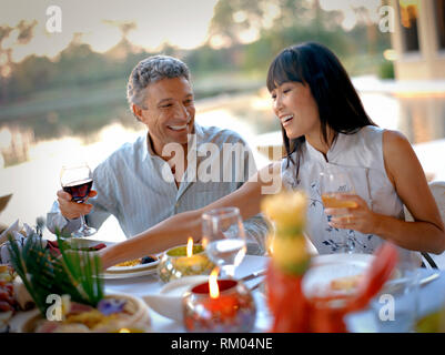 L'homme et la femme en riant pendant un dîner. Banque D'Images