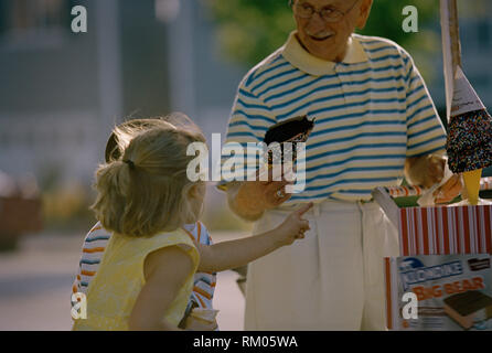 Jeune fille en pointant sur un cornet de crème glacée sur une glace panier. Banque D'Images