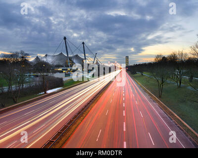 Light trails de voitures/passé au transport de l'architecture moderne dans une ville - Munich, Allemagne Banque D'Images