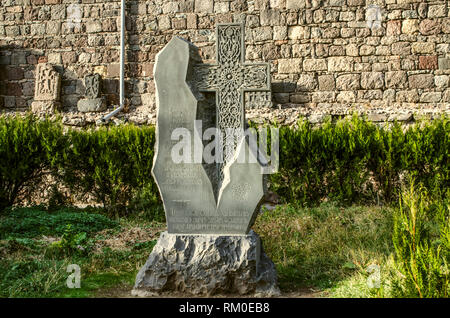 Guéghard, l'Arménie, le 20 octobre 2018:Khatchkar à partir de basalte taillé comme un l'au monastère et installé dans le parc près du mur de pierre, situé à une Banque D'Images