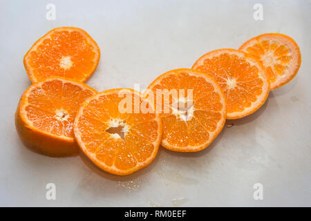 Freshly sliced oranges sur une planche à découper, montrant l'intérieur de fruits juteux Banque D'Images