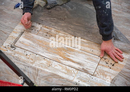 Carreaux de sol de pose sur le bâtiment de l'adhésif. Professions Banque D'Images