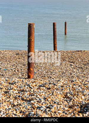 De pieux d'acier rouillé menant de la plage de galets de la mer à la baie de Sandwich, Kent, UK. Banque D'Images