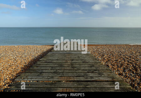 Une cale en bois mène de la plage de galets de la mer à la baie de Sandwich, Kent, UK. Banque D'Images